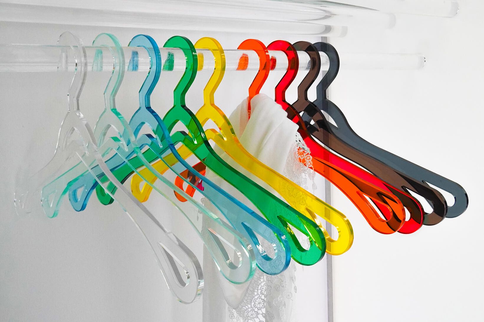 Acrylglas Kleiderbügel in verschiedenen Farben fotografiert auf einer Garderobenstange.